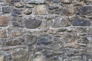 Full frame abstract texture background of a rugged medieval stone wall circa 16th century, with...