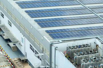 Solar energy for factory and warehouse building. Solar panels on roof of industrial plant. Commercial solar power. Rooftop solar power. Rooftop renewable energy system. Sustainable green energy.