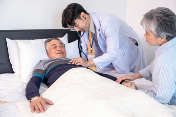Obraz premium old man end stage patient on bed,on IV drip,worried wife sit beside,doctor physically examine,home care,chronic care,breaking bad news,communication