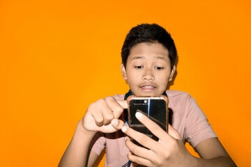 A boy is scrolling through his phone.