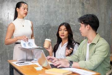 A team of professional young Asian startup members is having a serious meeting to plan a project.