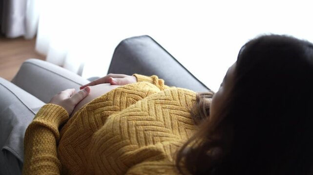 Pregnant woman wrapping hands on belly contact with her baby caring about her health