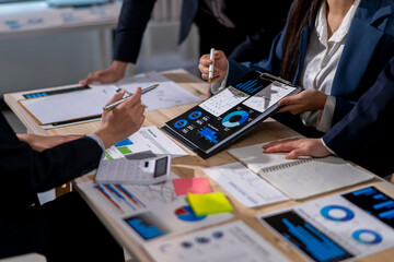A group of people are working on a project, with one person holding a tablet