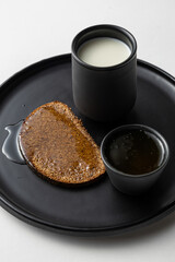 Simple Rye Bread with Honey and Milk on dark plate white background