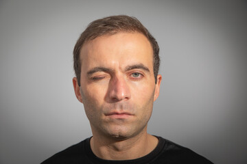 Fototapeta premium Caucasian man looking at camera and winking.