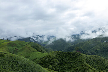 Naklejka premium Landscape of Morning Mist with Mountain Layer at north of Thailand. mountain ridge and clouds in rural jungle bush forest