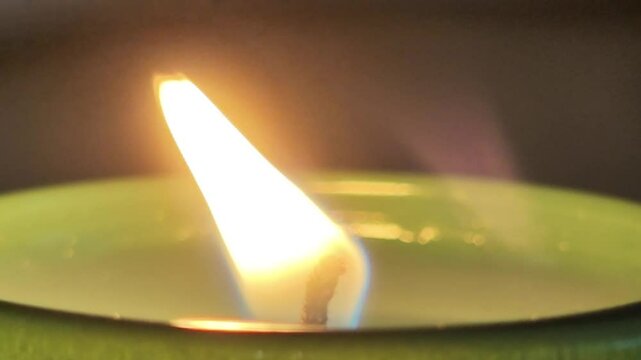 bright candlelight flame burning candle in green glass jar close up view thoughts and prayers condolence concept clip