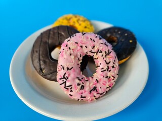 Colorful assortment of donuts displayed on a white plate against