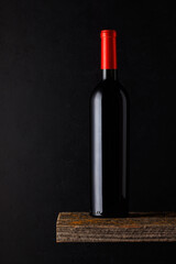 A bottle of red wine, set against a dark background