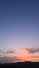 a sunset with a mountain in the background, sky setting
