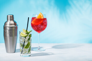 A variety of cocktails arranged on a table against a light blue background