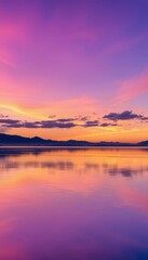Fototapeta premium purple and orange sunset over a calm lake with mountains in the distance