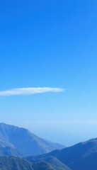 Fototapeta premium mountains with a few clouds in the sky and a person on a horse
