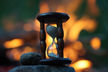 Retro hourglass on fire background in darkness. Time is running out.