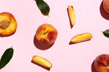 Sweet peaches and leaves on pink background