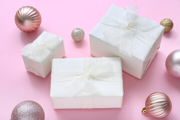 Christmas balls and gift boxes on pink background