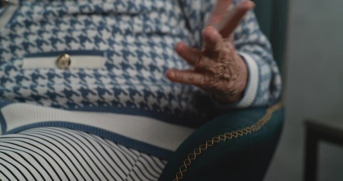 Close up of elderly patient's hand during therapy session. Woman sitting in chair discussing psychological problems and mental trauma in therapy session Psychology concept. Psychotherapy for elderly.