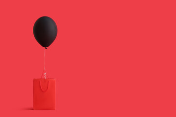 Shopping bag with beautiful air balloon on red background. Black Friday sale
