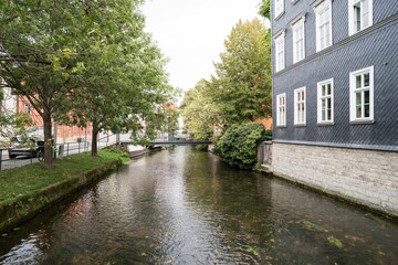 Canal with a bridge and adjacent buildings in a quaint urban setting. Erfurt, Germany