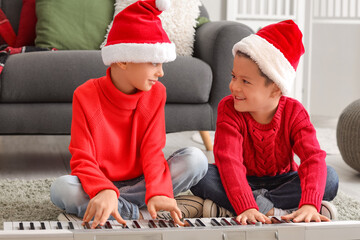 Cute little boys playing synthesizer at home on Christmas eve