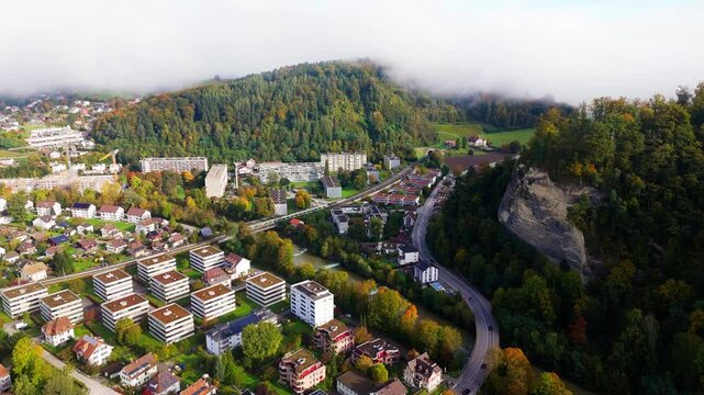 BLS Train cross the river Emme over a bridge in Burdorf Switzerland into a tunnel.