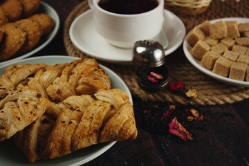 Sweet breakfast. Cup of tea with sweets on a dark table