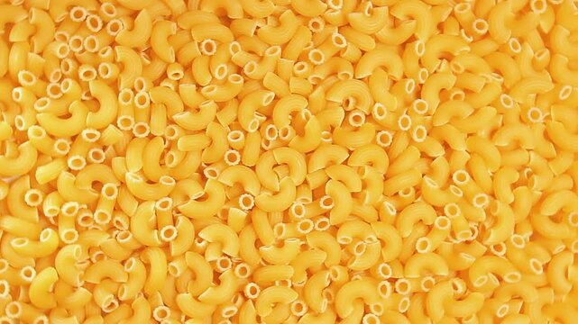 Uncooked Chifferi Rigati Pasta - Top View. Fat and Unhealthy Food. Classic Dry Macaroni, Slowly Rotating Background. Italian Culture and Cuisine. Raw Golden Pasta Texture - Right Rotation