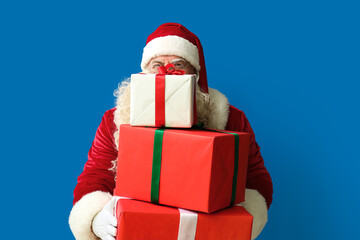 Santa Claus with Christmas gifts on blue background