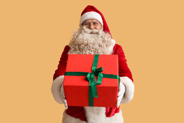 Santa Claus with Christmas gift on yellow background