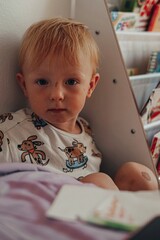 baby child with red hair  playing with a book