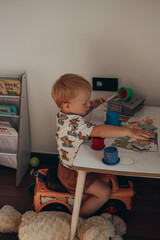 a boy with red hair just woke up and is playing in his children's room