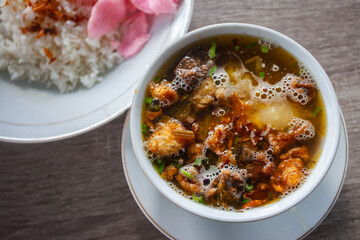 Soto Padang (Padang Soup), a traditional dish originating from Padang, West Sumatra, Indonesia. A soup filled with beef and offal and vegetables, eaten with rice and crackers.