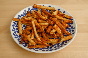 Piękne apetyczne domowe frytki z ziemniaków smażonych w głębokim oleju, niezdrowe jedzenie 