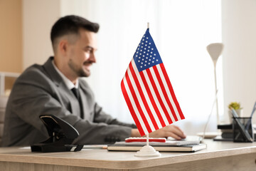 Handsome young happy businessman with laptop and flag of USA in office © Pixel-Shot