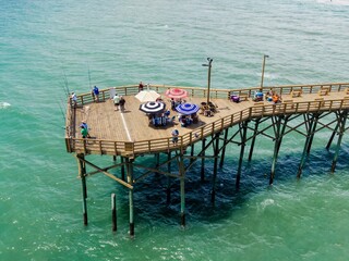 Poeple fishing off Surf City Ocean Pier and beach umbrellas, Surf City, North Carolina, United...