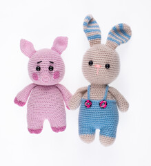 knitted toy pig and rabbit isolated on white background