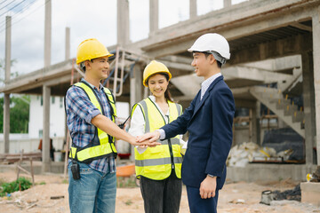 Architect Asian team working with colleagues in the construction site. Architecture engineering on big project.