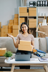 Young business owner woman prepare parcel box and standing check online orders for deliver