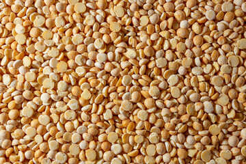 Uncooked Polished Split Peas Background. A Culinary Canvas of Dry Yellow Peas, Creating a Lively and Textured Background for Gourmet Cooking. Scattered Raw Polished Peas. Healthy Eating Ingredients