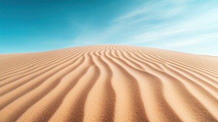 Naklejka premium A vast desert sand dune features smooth, flowing ripples under a bright, clear blue sky, evoking tranquility and the serene beauty of the natural world.