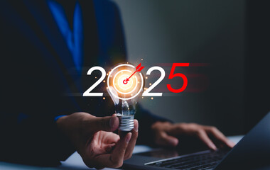 2025 business goals and strategy planning concept. Businessman holds lightbulb with a target symbol...