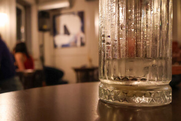 Glass of Water with Ice on a Table in a Cozy Café