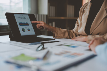 Two Asian businesswomen use laptops and smartphones in an open space office. Business concept. Data analysis, roadmap, marketing, accounting, auditing.