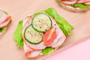 Light Breakfast. Quick and Healthy Sandwiches. Rice Cakes with Ham, Tomato, Fresh Cucumber and Green Salad on Wooden Cutting Board