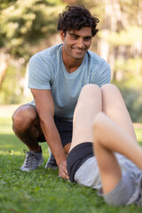 shot of young man and woman stretching in the park