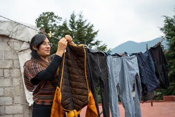 Young Mexican woman hanging clothes to dry in the sun