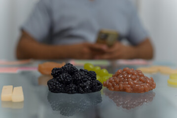 Artificial samples of blackberries, grapes and beans on the table in the office of the nutritionist.