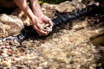 many pebbles are placed in a garden pond for decoration