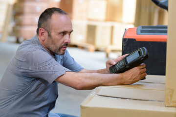 warehouseman with scanner and laptop in warehouse