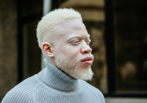 A man stands outdoors, wearing a cozy turtleneck sweater - Powered by Adobe